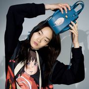model wears studio ghibli spirited away shirt and poses with bag on head