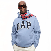 dapper dan wears the dap gap hoodie while standing in front of a plain backdrop