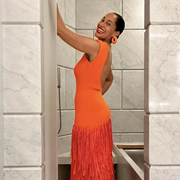 tracee poses in orange dress against marble walls